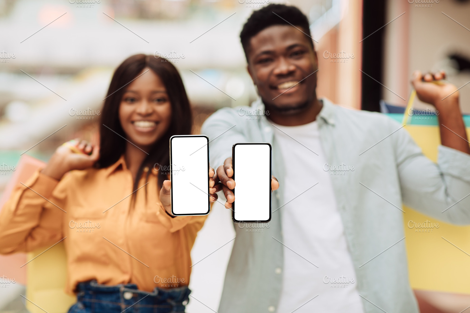 Black couple showing blank empty smartphone screen for mockup, a Photo by Prostock-Studio