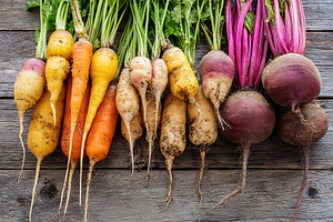 Seasonal root vegetables showcased on wooden surface from local farm harvest, a Photo by AlyaAnd