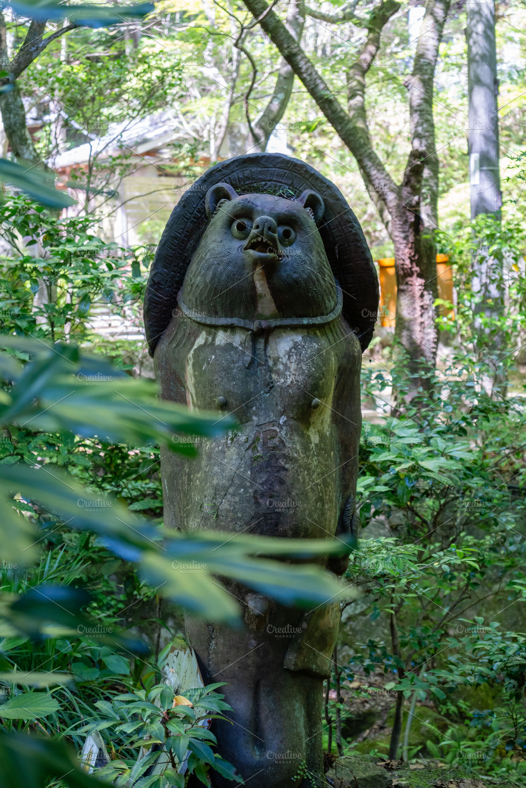 Tanuki statue surrounded by greenery at Mitaki-Dera in Hiroshima, a Nature Photo by GoodGoods