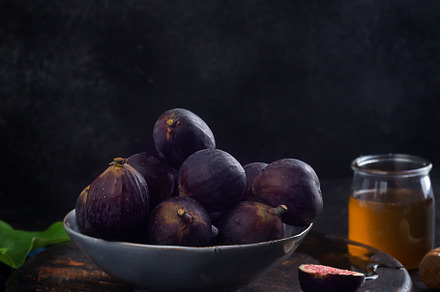 Fresh figs on a dark wood background containing fig, purple, and dark, a Food & Drink Photo by zakiroff