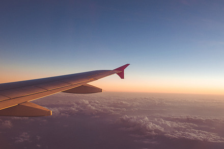 Airplane wing with sunrise featuring above, aircraft, and airplane