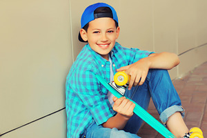 Happy smiling teenager boy with skat