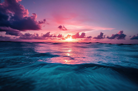 Vibrant sunset over calm ocean water, a Photo by Tanuart
