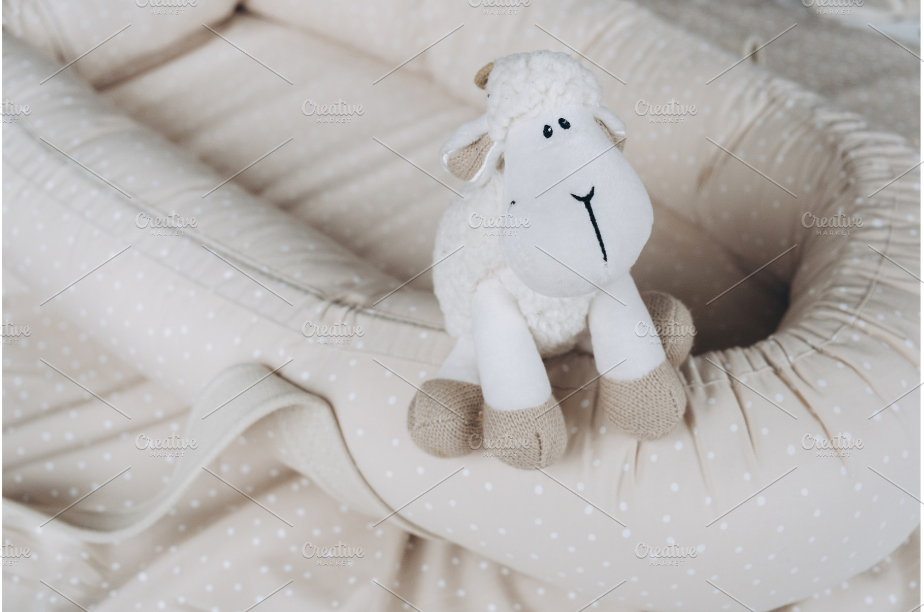 Soft sheep toy on beige cocoon, baby, a Person Photo by Enjoy Photo