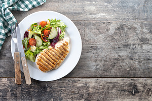 Healthy grilled chicken with salad on wooden table, a Food & Drink Photo by etorres69