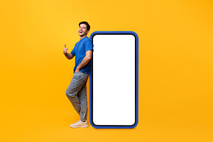 Guy leaning on white blank smartphone screen showing thumbs up