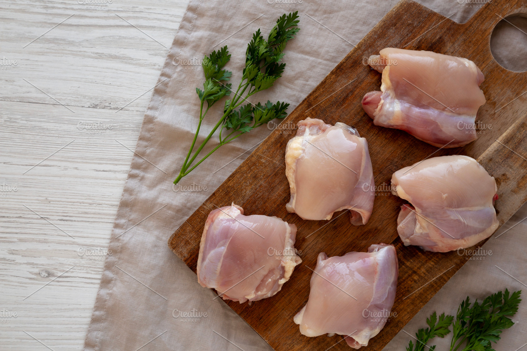 Raw Organic Boneless Skinless Chicken Thighs on a Wooden Board,, a Food & Drink Photo by LiudmylaChuhunova