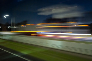 Light trails of a moving vehicle at night on the road, an Architecture Photo by GoodGoods