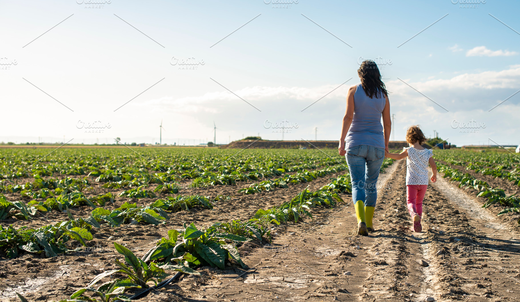 Woman farmer and little girl walking featuring woman, child, and garden, a Person Photo by Deyan Georgiev
