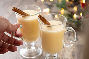 Hand picking up a glass of eggnog from a Christmas table, a Food & Drink Photo by etorres69