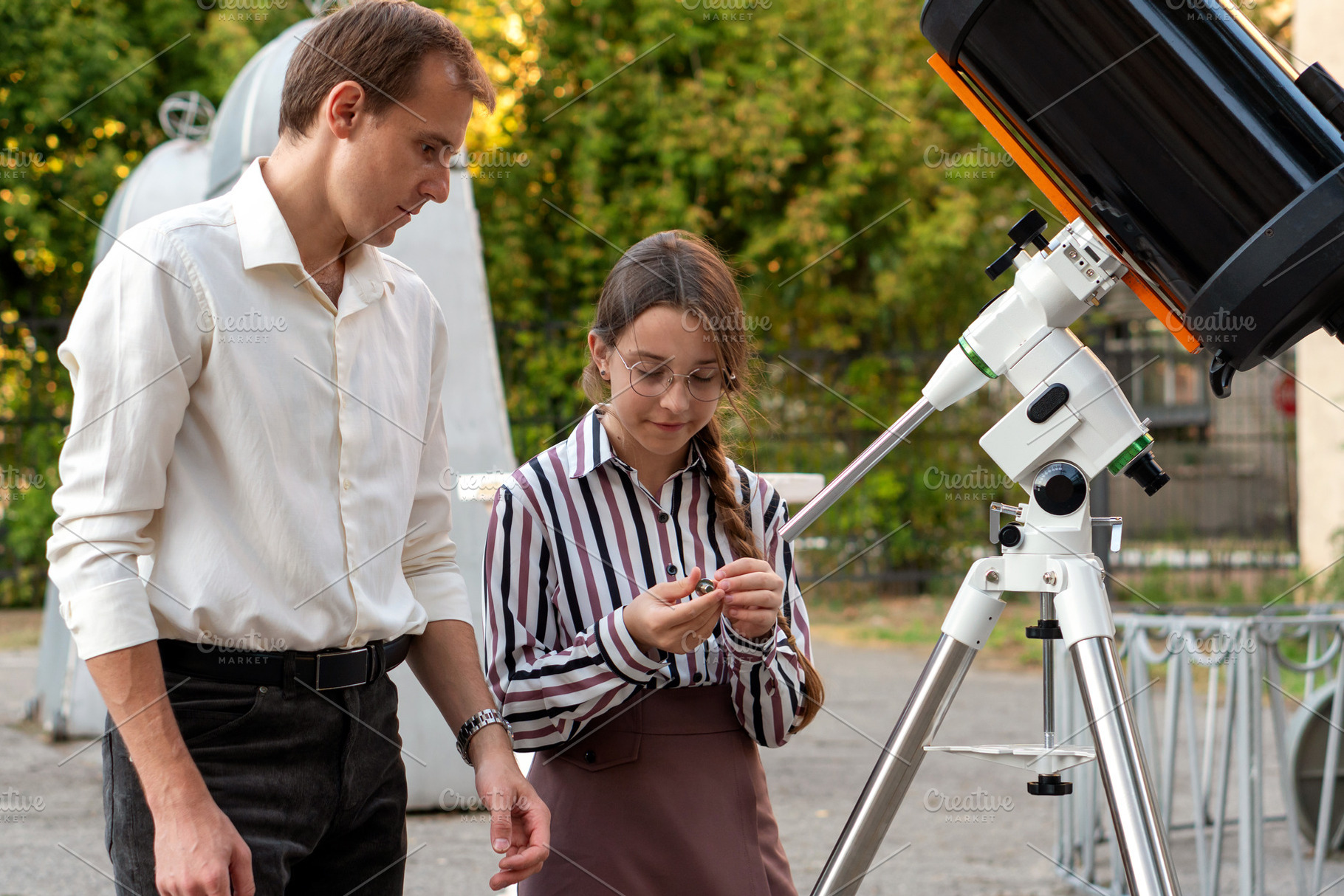 Student examines telescope part, a Person Photo by Elena Vagengeim