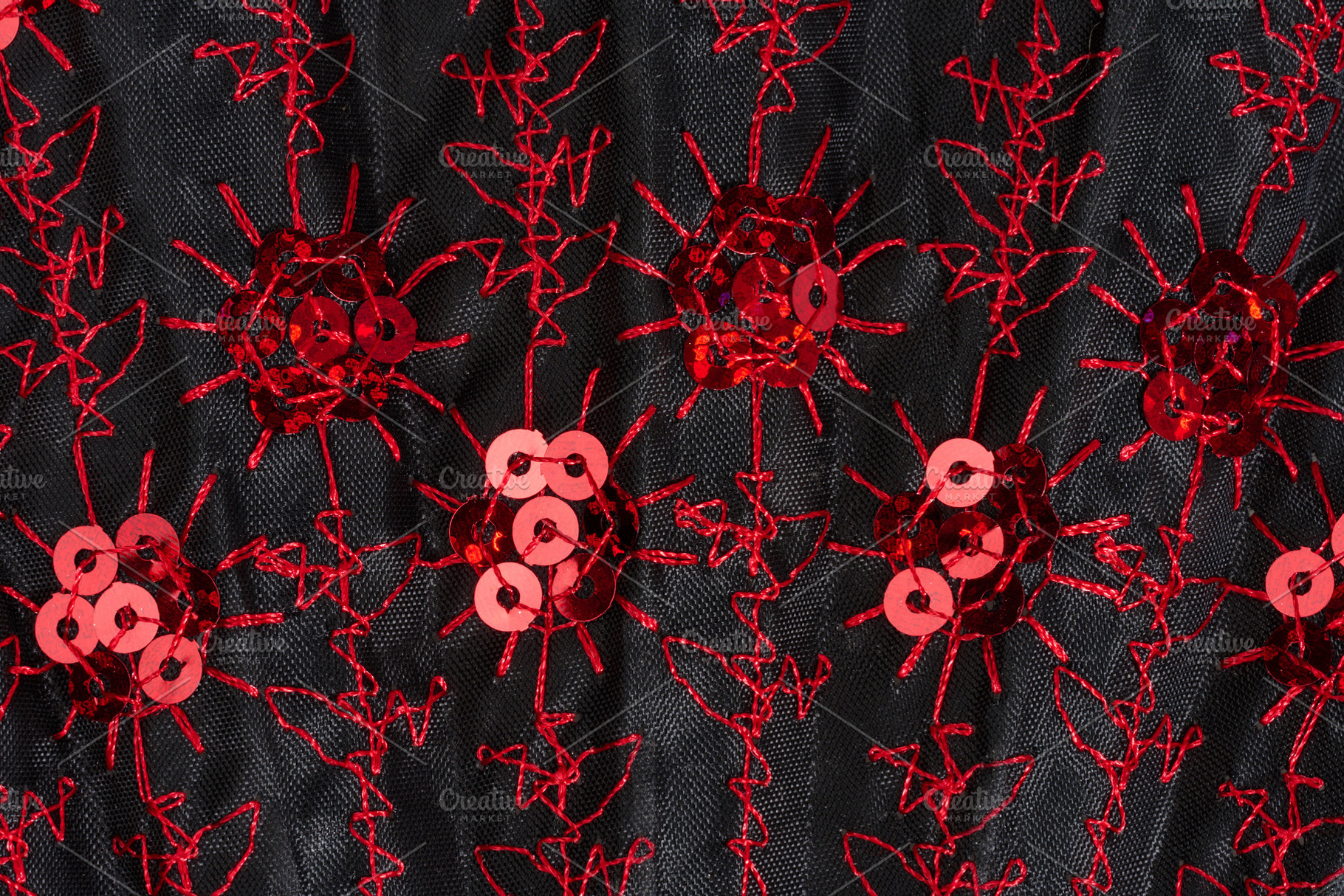 Black fabric with red embroidery and shiny sequins close-up, a Beauty & Fashion Photo by ndanko