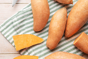 Preparing raw sweet potatoes for healthy cooking, a Food & Drink Photo by Olena Rudo