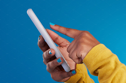 Phone, typing and hands of woman point to screen in studio for social media, text message and website. Communication, technology and girl on internet, networking and chat online on blue background, a Photo by Peopleimages.com