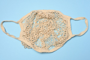 A beige handmade mesh shopping bag on a blue background. Eco-sho, a Background Photo by ndanko