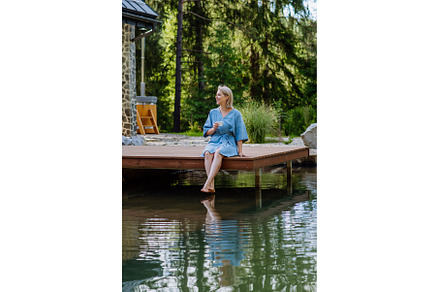 Happy young woman sitting by pond, a Sports & Recreation Photo by HalfPoint