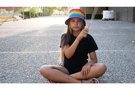 A young girl holds a rainbow lgbtq