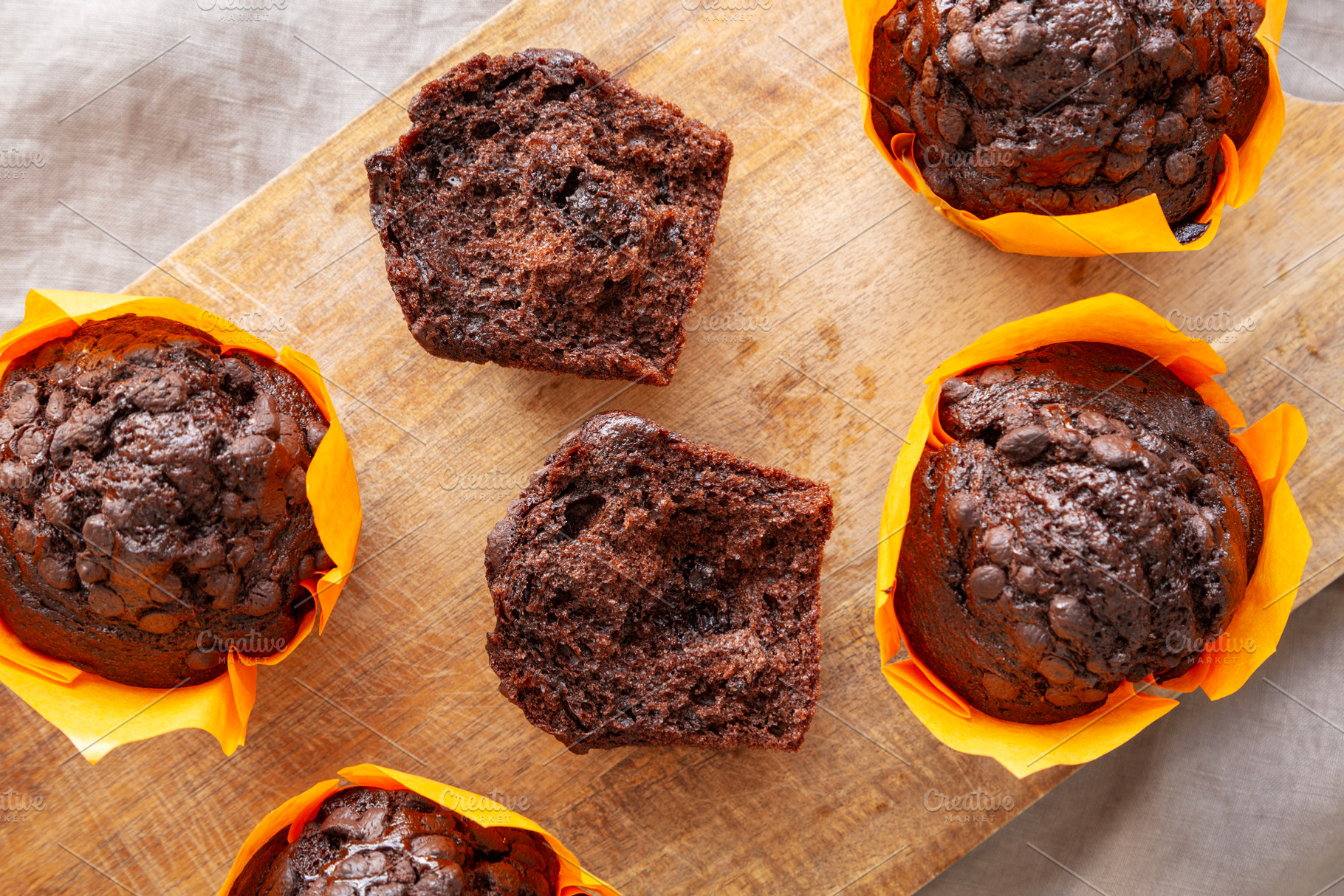 Homemade Chocolate Chip Muffins on a wooden board, top view. Clo, a Food & Drink Photo by LiudmylaChuhunova
