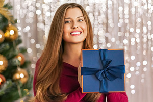 Young woman receiving a Christmas gift, smiling with happiness d, a Person Photo by Studio ANNA