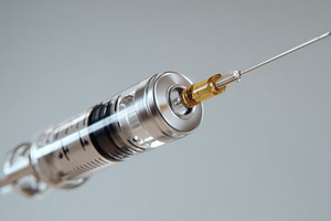 A close-up view of a clear syringe filled with a golden liquid, showcasing the, a Business Photo by ImageMir
