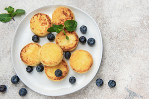 Syrniki cottage cheese pancakes with fresh blueberries and mint, a Food & Drink Photo by Olena Rudo