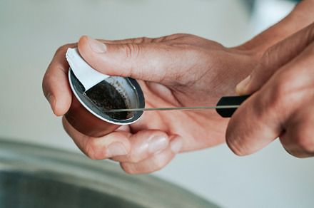 man empties a used coffee capsule, a Photo by Nito