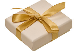Beige gift box with golden satin ribbon on isolated background, a Holiday Photo by ndanko