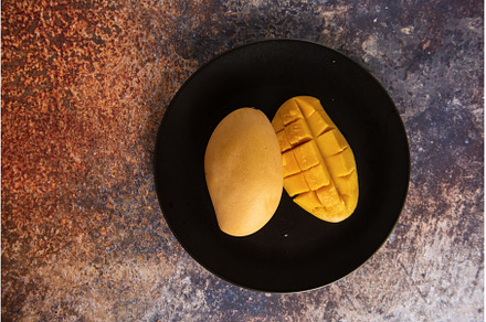 Fresh yellow mango fruit in a black, a Food & Drink Photo by Jan Jack Russo Media