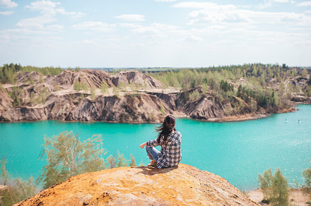 Young woman sitting on the top of mounting and feeling free and looking at the, a Person Photo by travnikovstudio