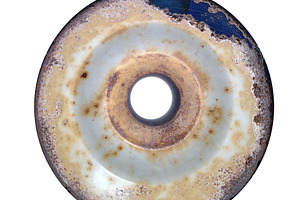 Rusted circular metal object on textured surface, an Abstract Photo by DanFLCreativo