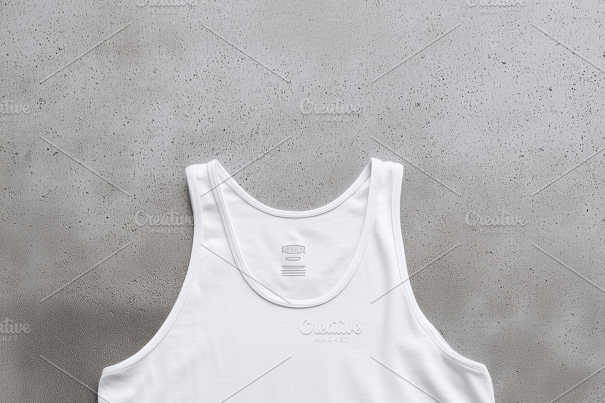 A plain white tank top mockup laid flat on a textured gray background, showcasi, a Shirt Mockup by Textures & Backgrounds