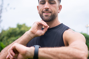 Athletic man checking smartwatch after outdoor workout in park, a Person Photo by etorres69