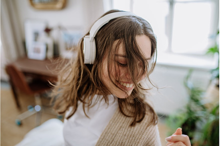 Young woman listening music trough, a Person Photo by HalfPoint