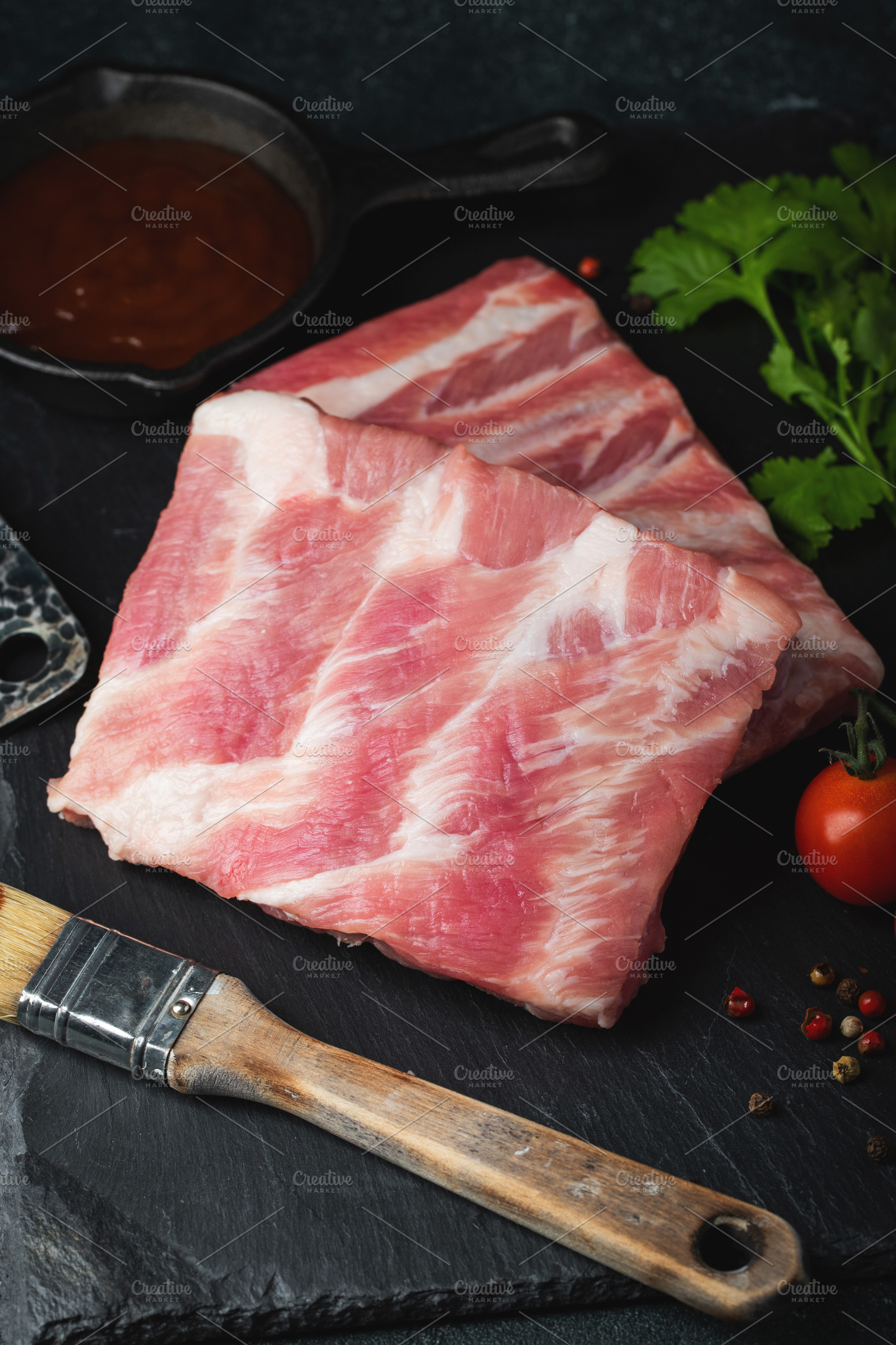 Raw meat. Raw pork ribs from the back with meat on a black background. backgrou, a Food & Drink Photo by Budarinphoto