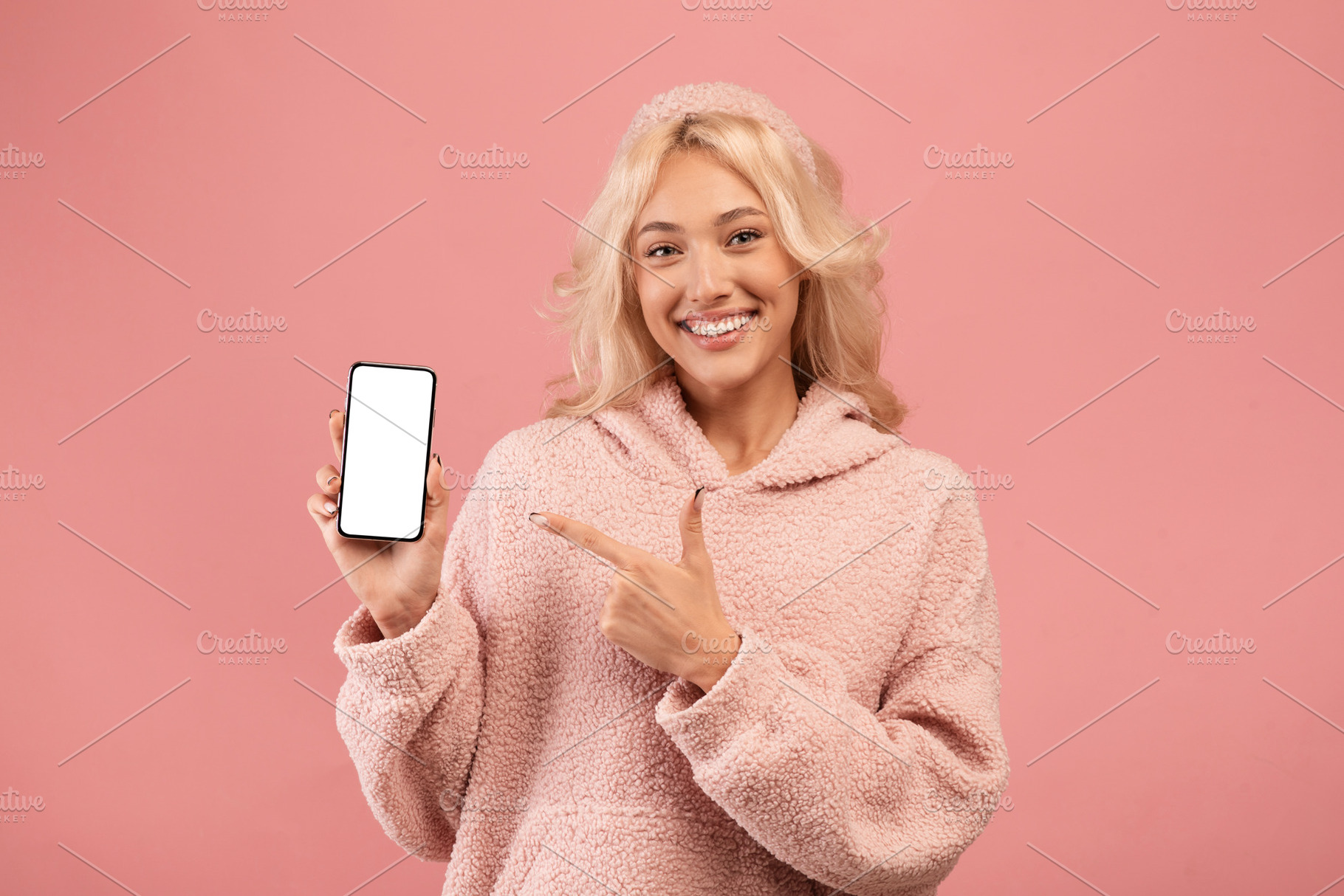 Great mobile app or website. Happy young woman holding modern smartphone and po, a Photo by Prostock-Studio