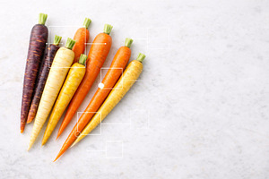Rainbow carrots on white marble back, a Photo by Dvoevnore photos