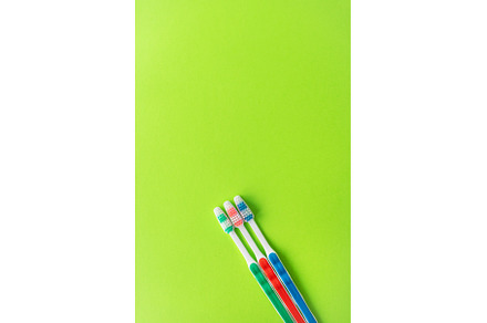 Multicolored toothbrushes on a green, a Health & Medical Photo by Artsaba Family