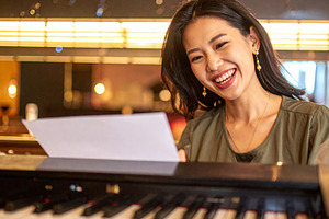 Adult pianist performing at the piano in a small bar, a Person Photo by DanFLCreativo