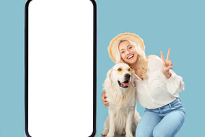 Happy woman sitting near her labrador dog and showing peace gesture, posing nea, a Photo by Prostock-Studio