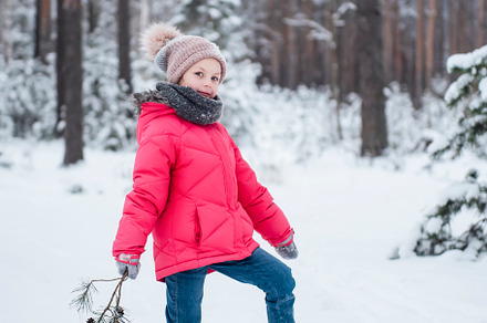 Little girl in a bright jacket plays in the winter forest, a Person Photo by Olena Rudo