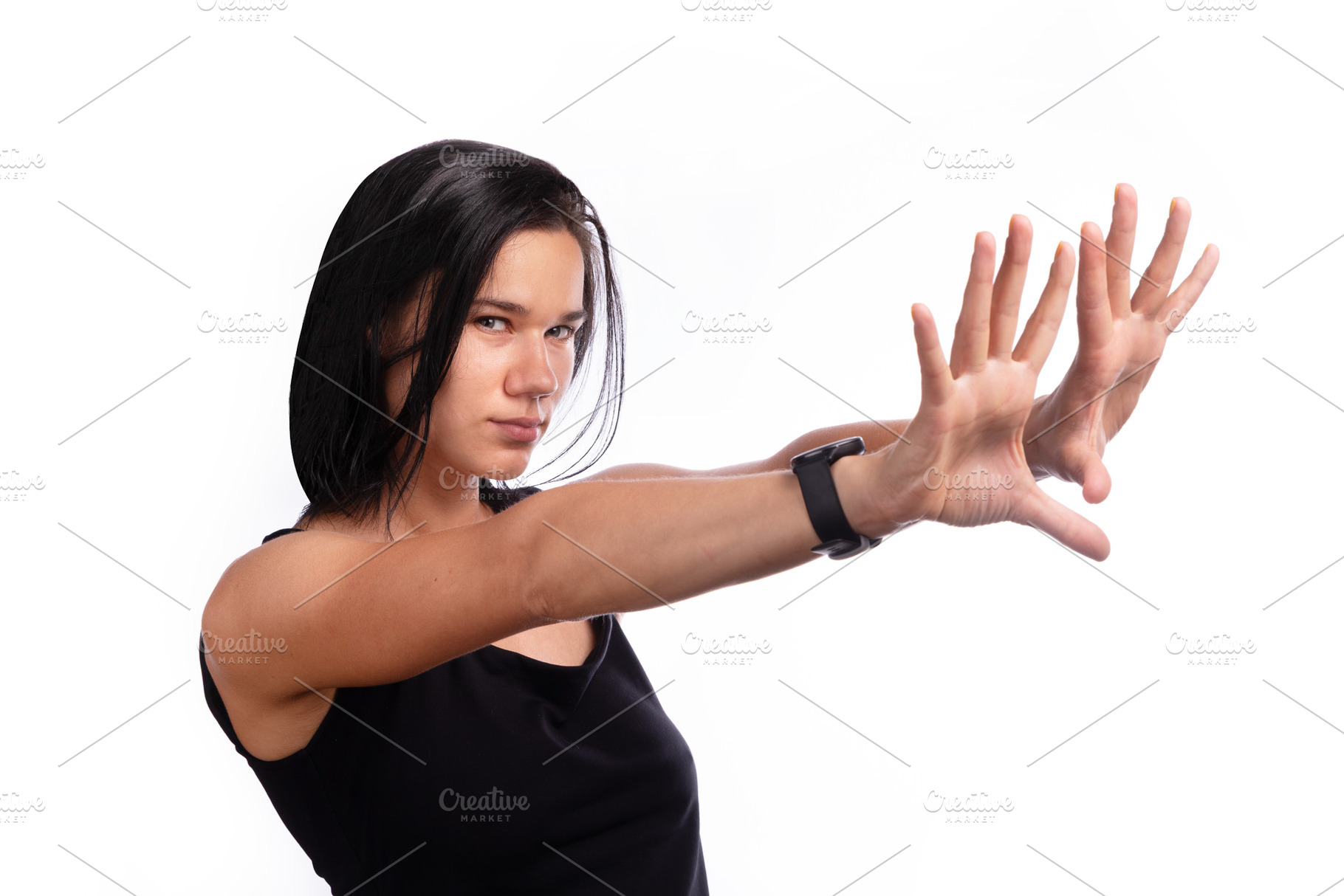 Young woman in black top reaching hands forward, showing determi, a Person Photo by Ales Munt