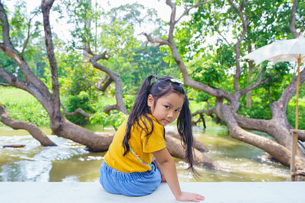Asian child cute or kid girl sitting near the river or public pa, a Person Photo by Casanowe-studio