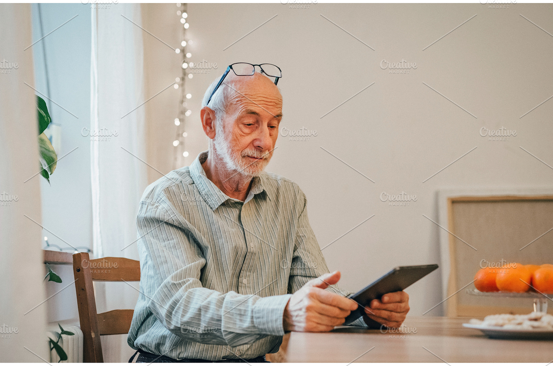 Older man working on tablet., a Technology Photo by HalfPoint