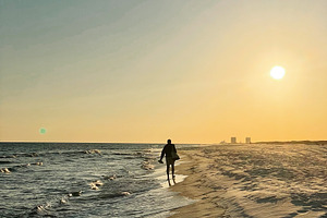 Silhouette of a person walking along a Florida Pensacola Beach at sunset with a, a Nature Photo by AS photostudio