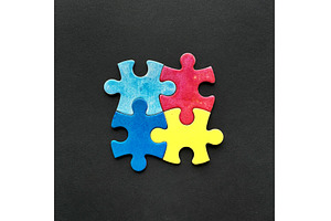 Four colorful puzzle pieces in red, a Photo by tilialucida