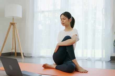 Asian women doing yoga exercises by themselves and watch video tutorials online