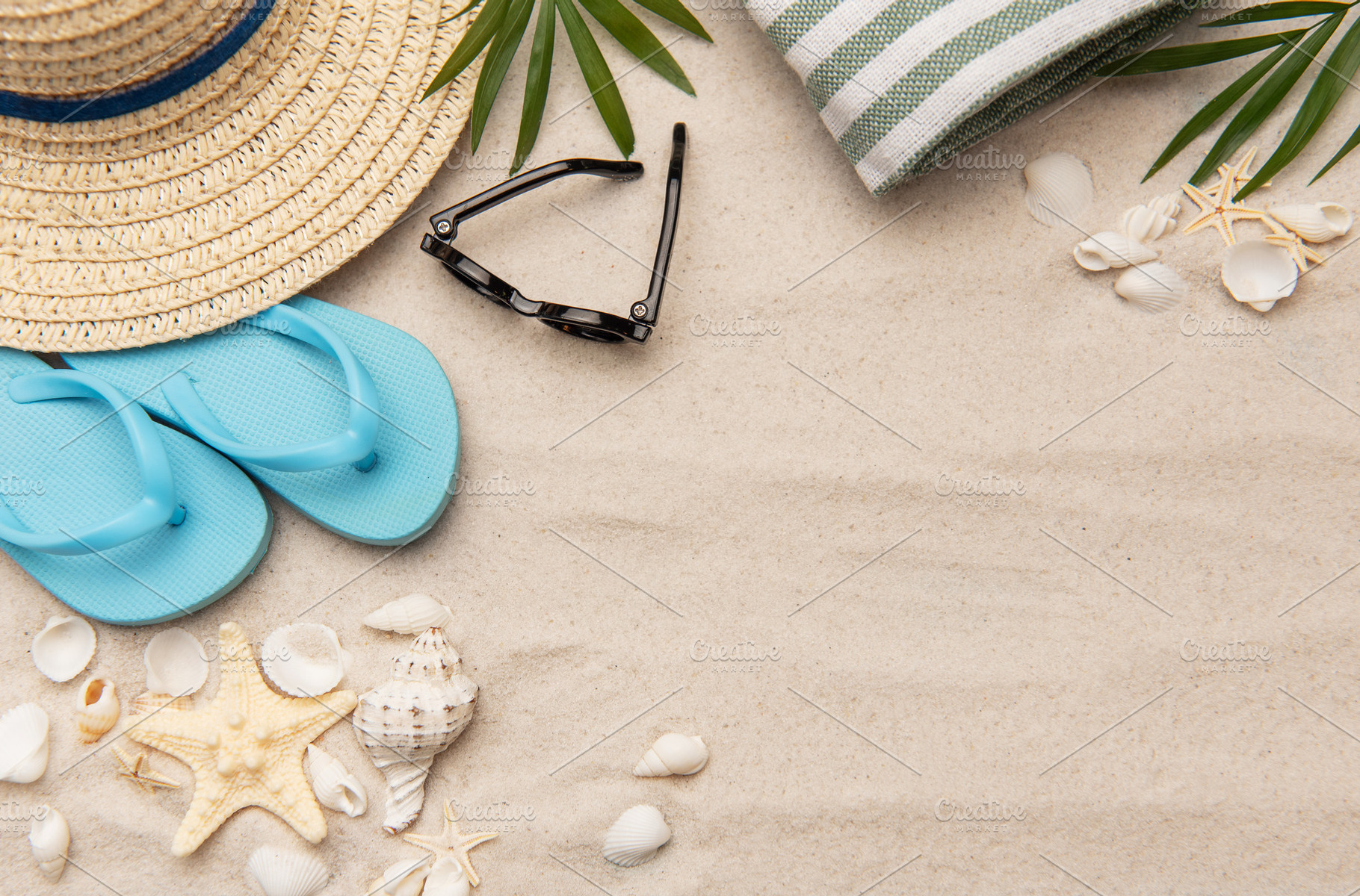 Beach accessories lying on sand creating summer vacation backgro, a Holiday Photo by Olena Rudo