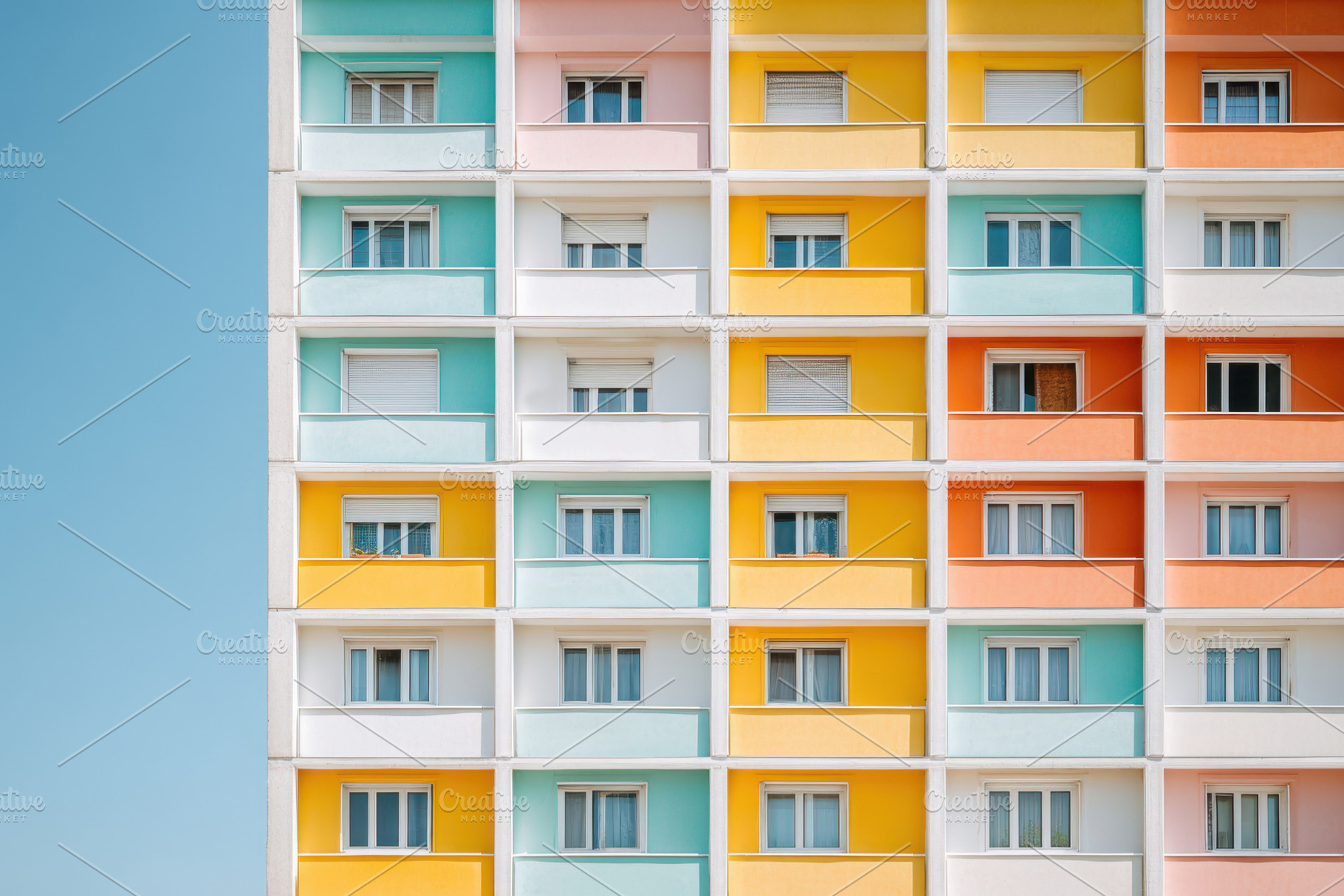 Colorful apartment building facade with pastel hues, an Architecture Photo by AlyaAnd
