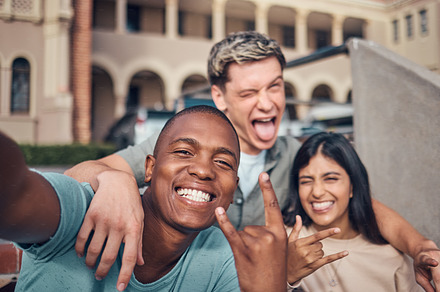 Friends selfie, smile and portrait on university campus with diversity, happy and funny face, hand gesture and rock sign. Happy, portrait and interracial college friendship, students and photograph, a Photo by Peopleimages.com