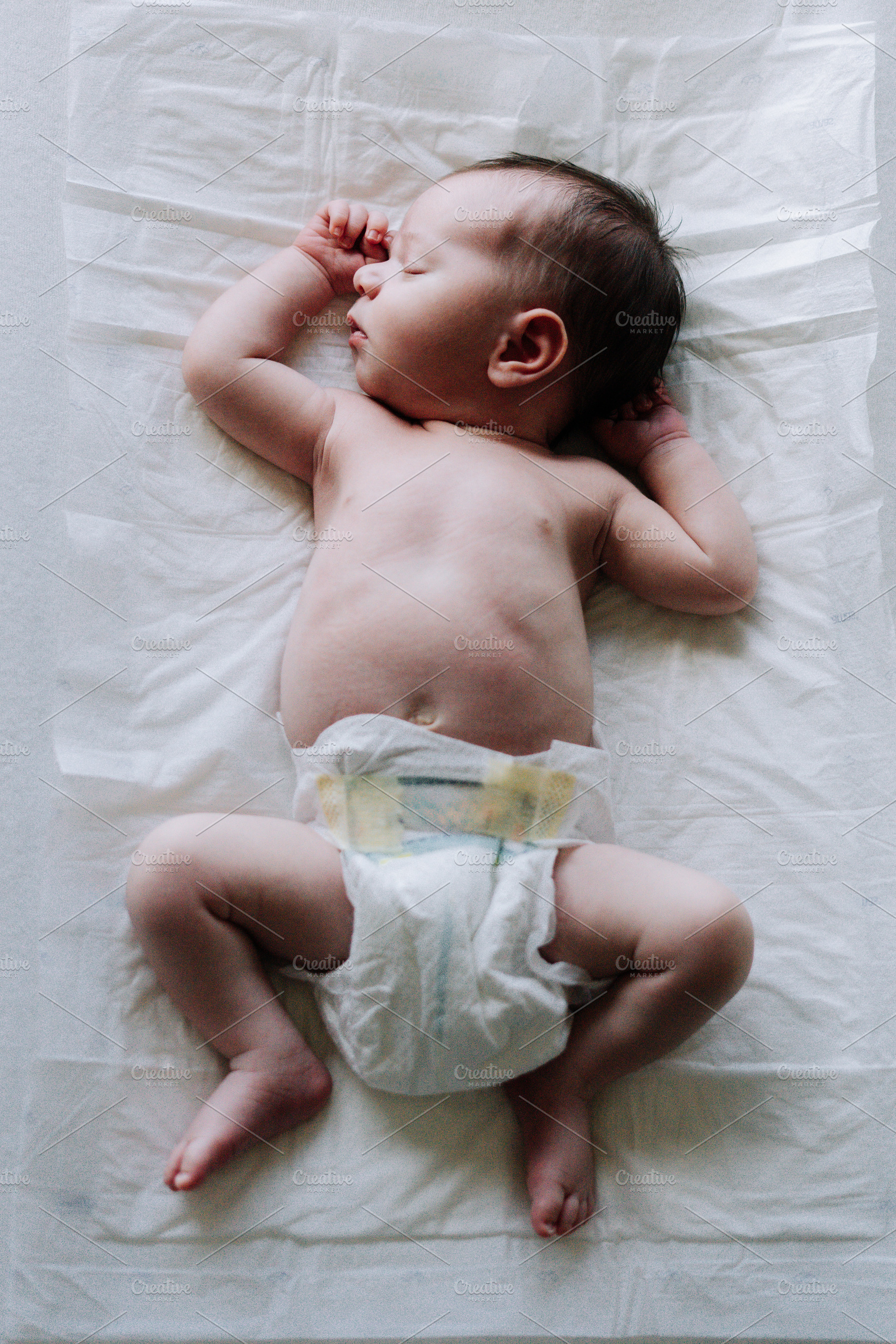 Portrait of a newborn on diapers on a baby changer, a Person Photo by rubenchase